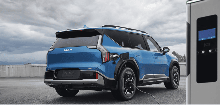 blue kia ev9 plugged into charger